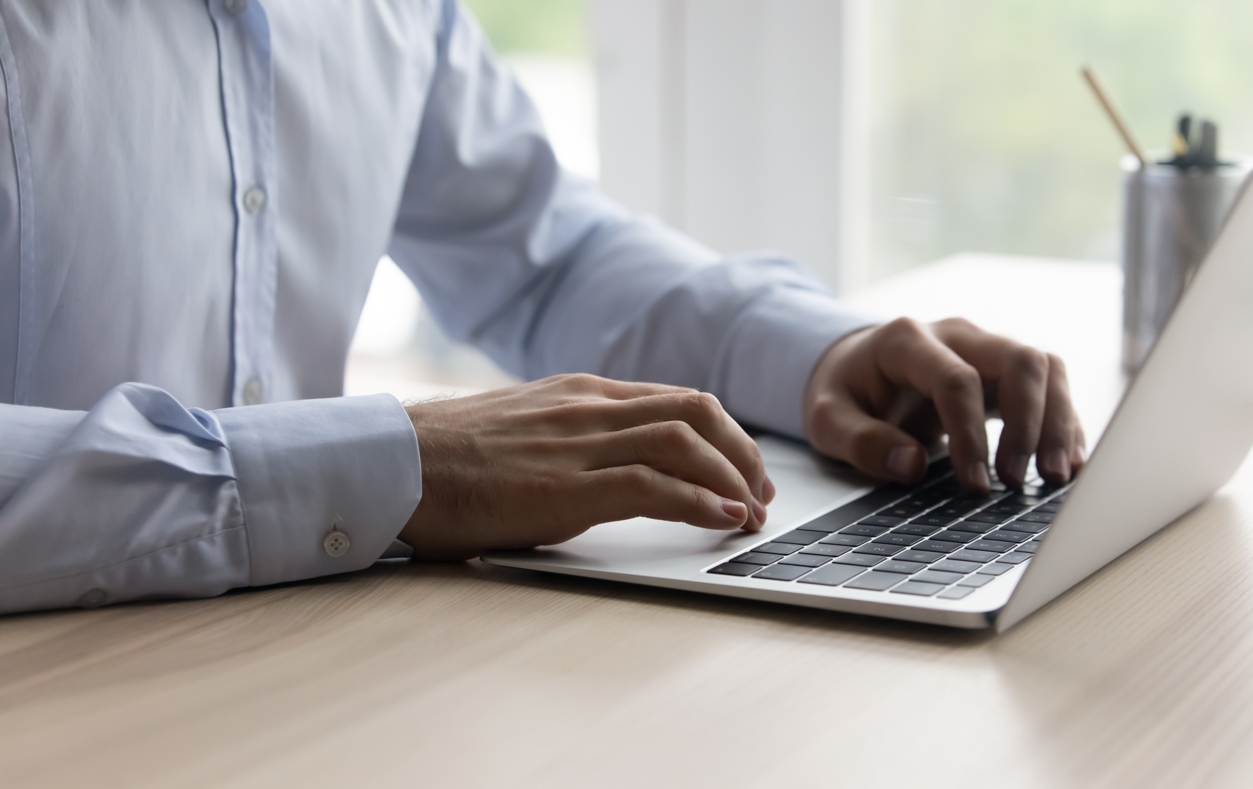 A financial professional typing on a computer.