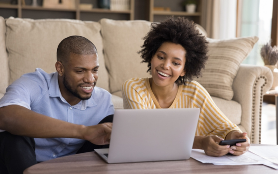 Couple works on personal finances on laptop