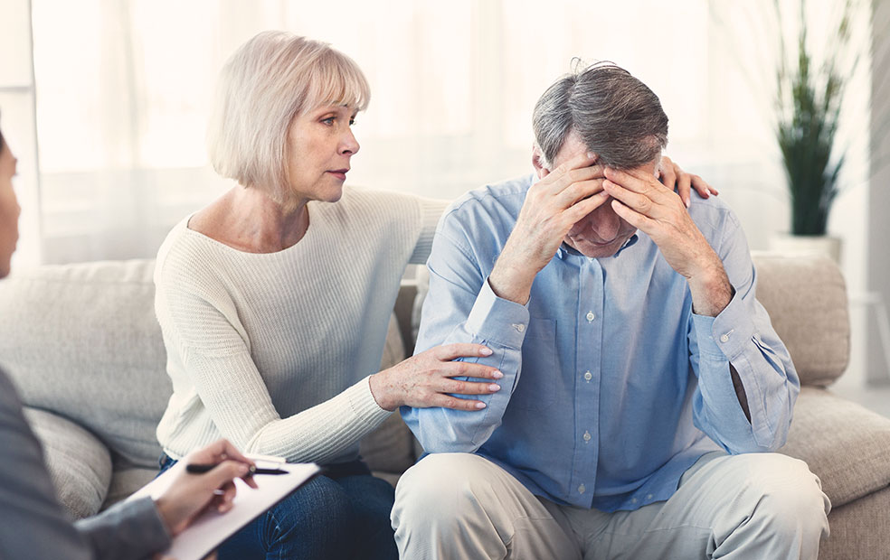 A couple comforting each other after receiving bad news from their financial planner.