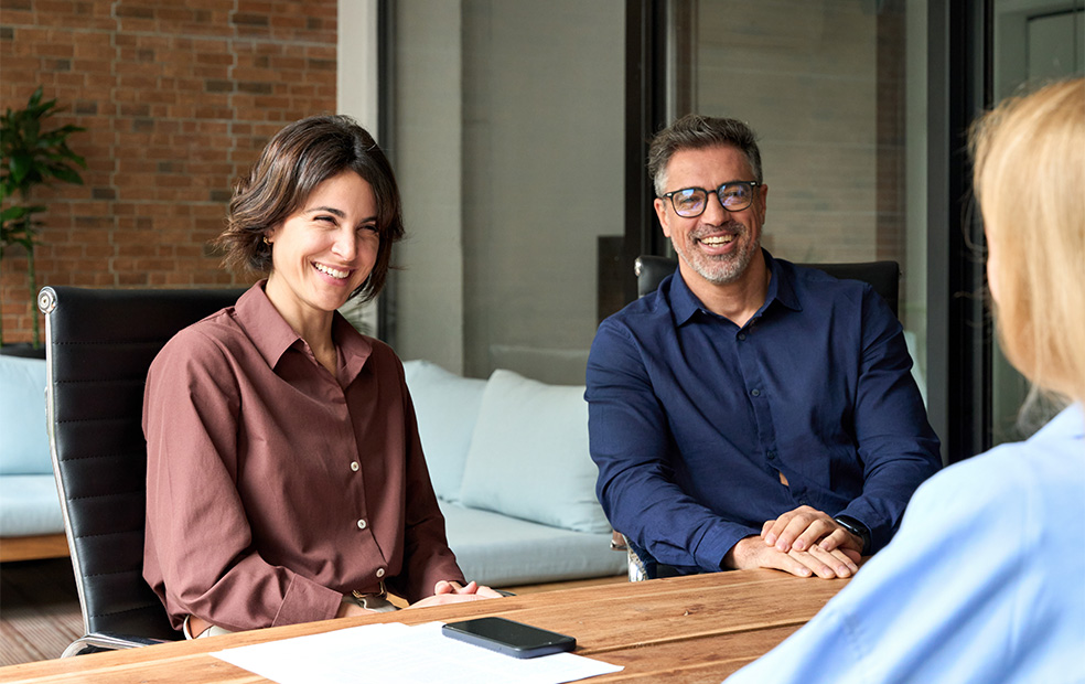 Two clients speak with their financial planner.