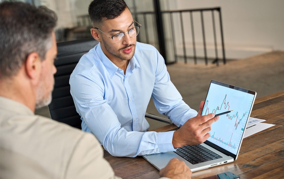 Advisor shares laptop image and discusses risk with client