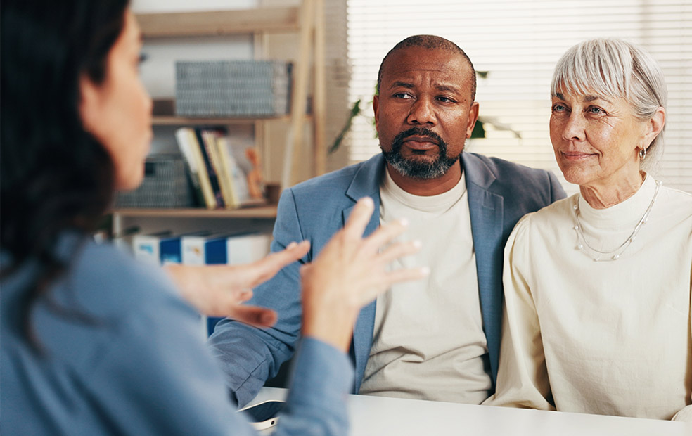 Financial advisor meeting with clients in an office setting, discussing financial goals and planning strategies through personalized communication and guidance.
