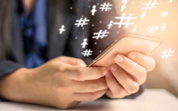 Hands holding smartphones to use hashtags