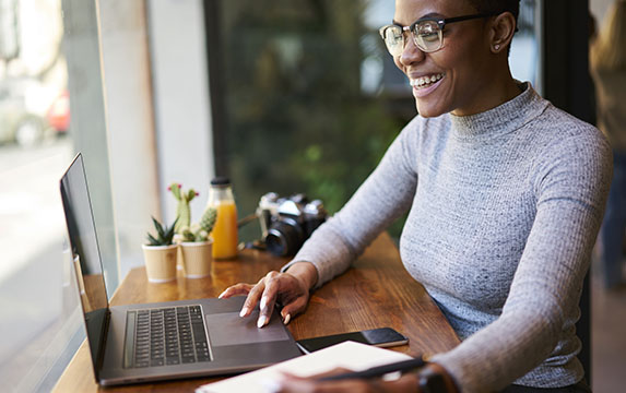 Woman smiling at desk on laptop
