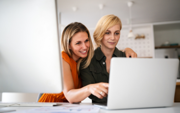 Lesbian couple reviews financial plan on a laptop