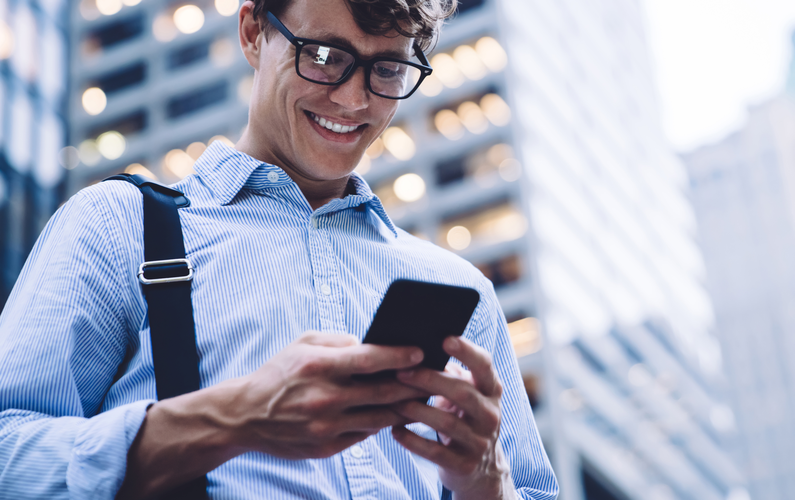 Man checking accounts on phone smiling