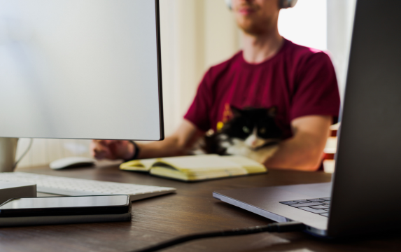 Man working from home with computer and cat