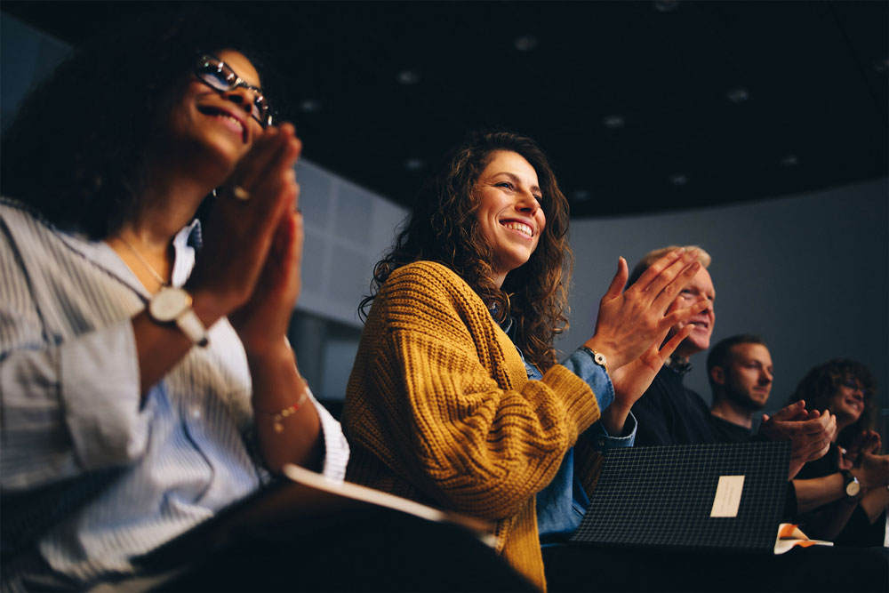 People in an audience applauding